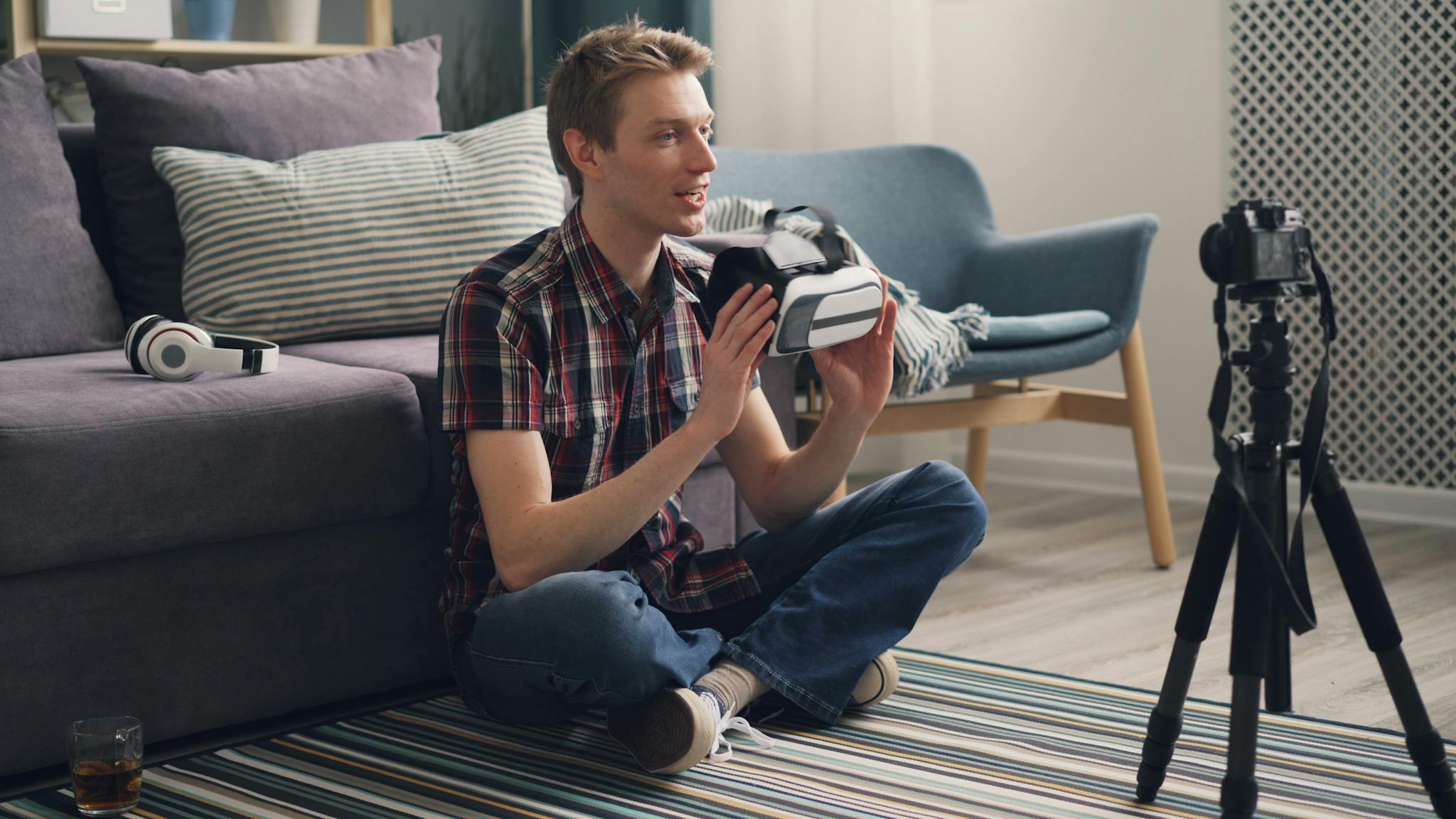 Casual setting with young adult exploring virtual reality headset technology indoors.